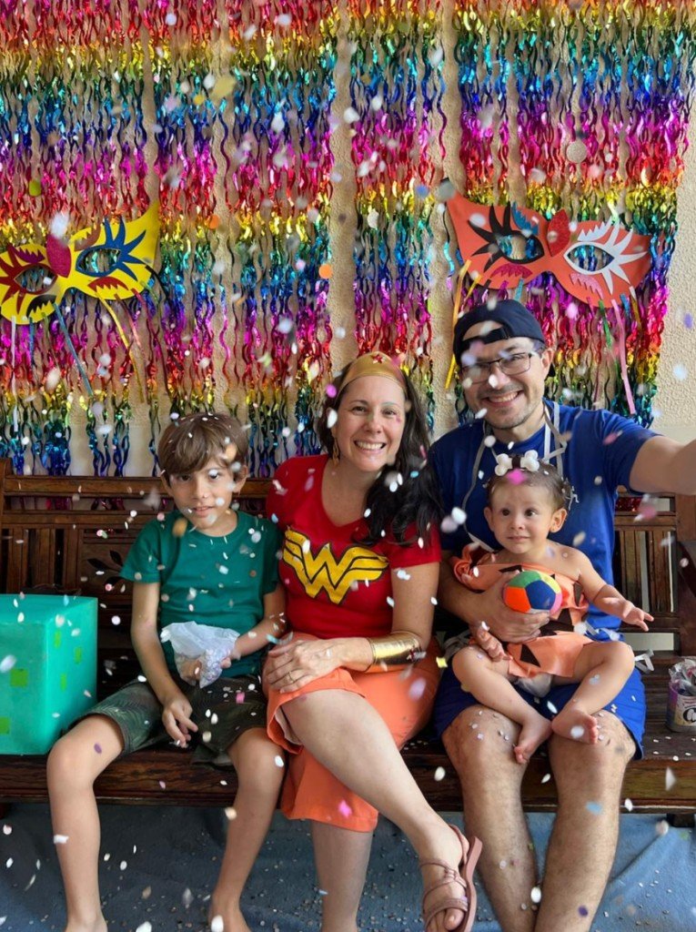 Família posando na festa de aniversário com decoração colorida no espaço do Novo Brincar