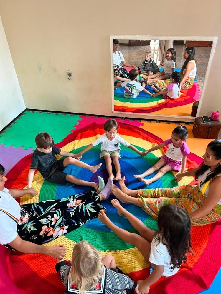 Roda de vínculo afetivo com as crianças em manta colorida no Novo Brincar